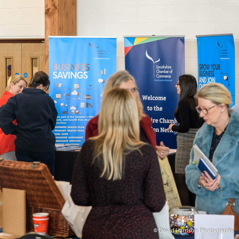 People stand in small groups talking in front of display stands