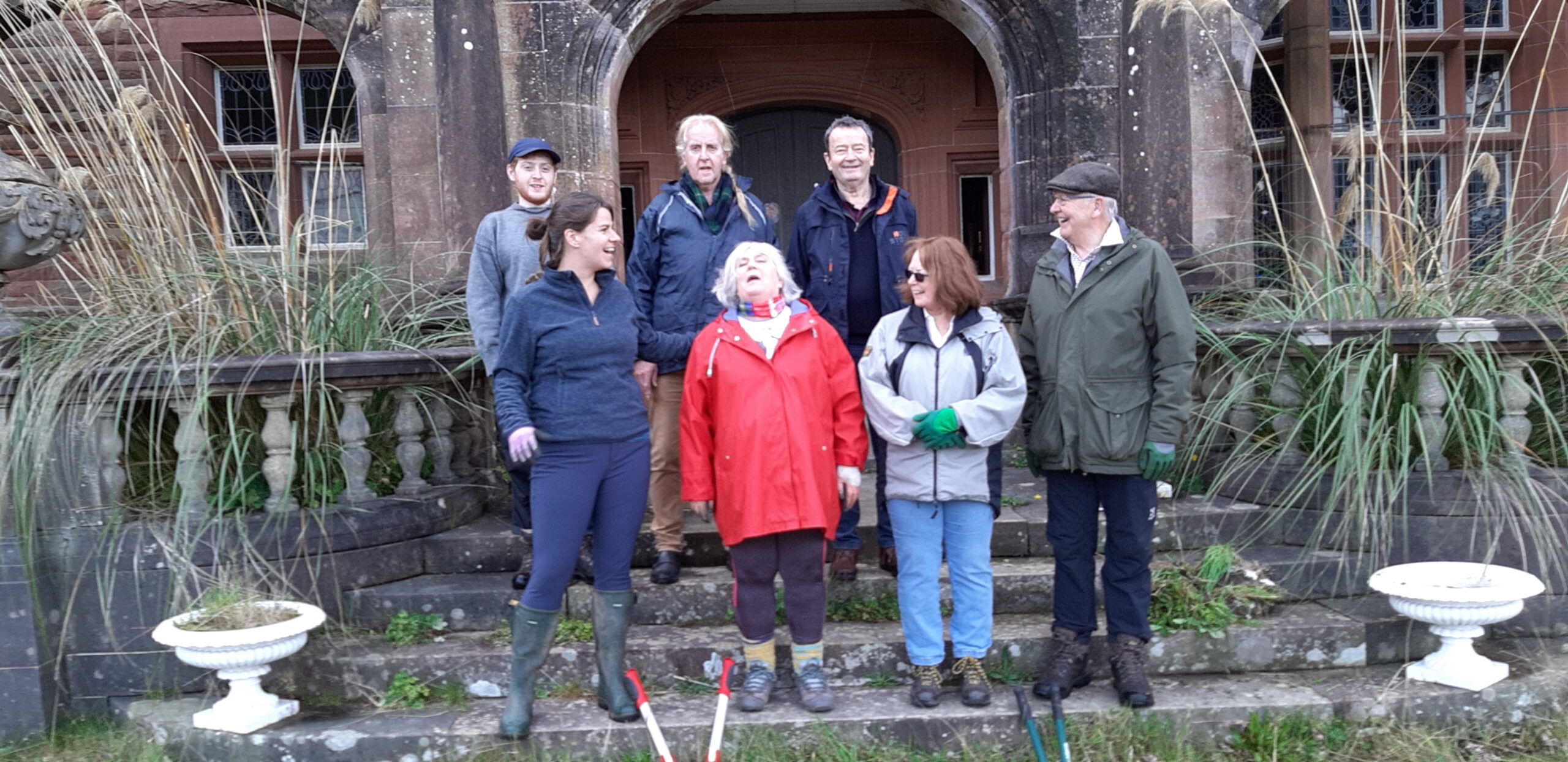 7 people posing on steps of a castle